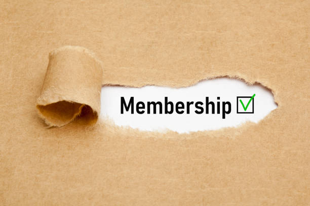 The word Membership with green verification check mark appearing behind torn brown paper.