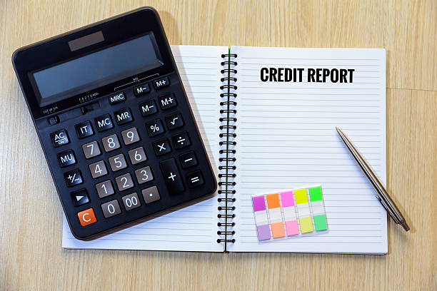Credit report on notepad with calculator, colorful bookmark and pen.