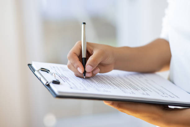 Holding clipboard and a pen in office